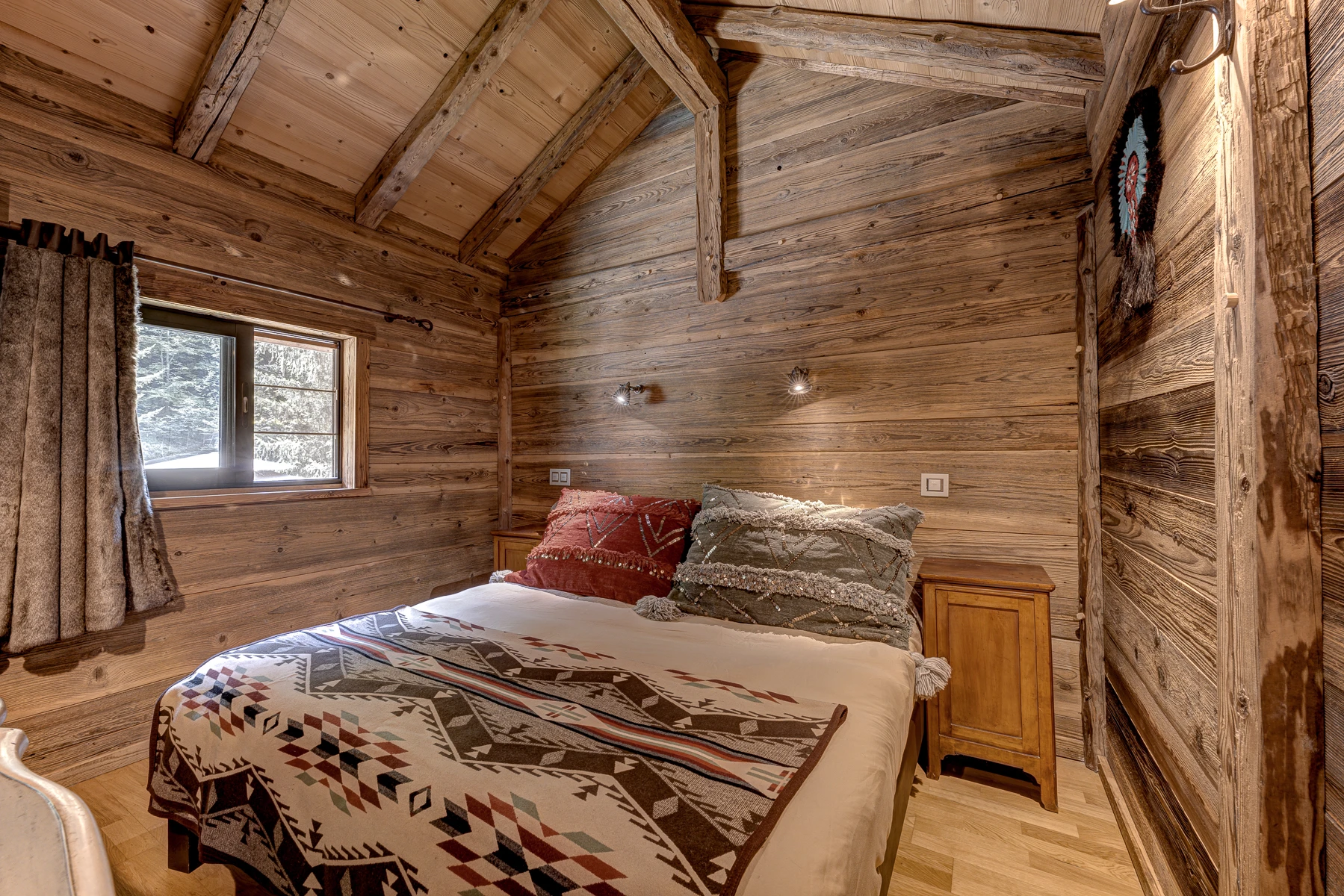 Photo de l'autre angle de la première chambre. Gros coussins, rangements, miroir, lit king size, décoration western Montana
