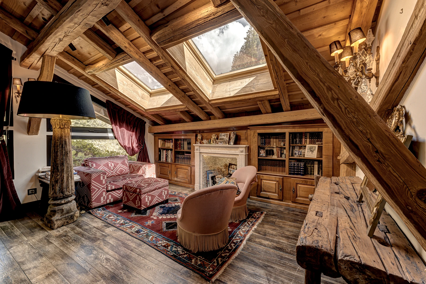Photo du coin bibliothèque de la chambre master. Sous les toits, vue sur les montagnes, ambiance chaleureuse.