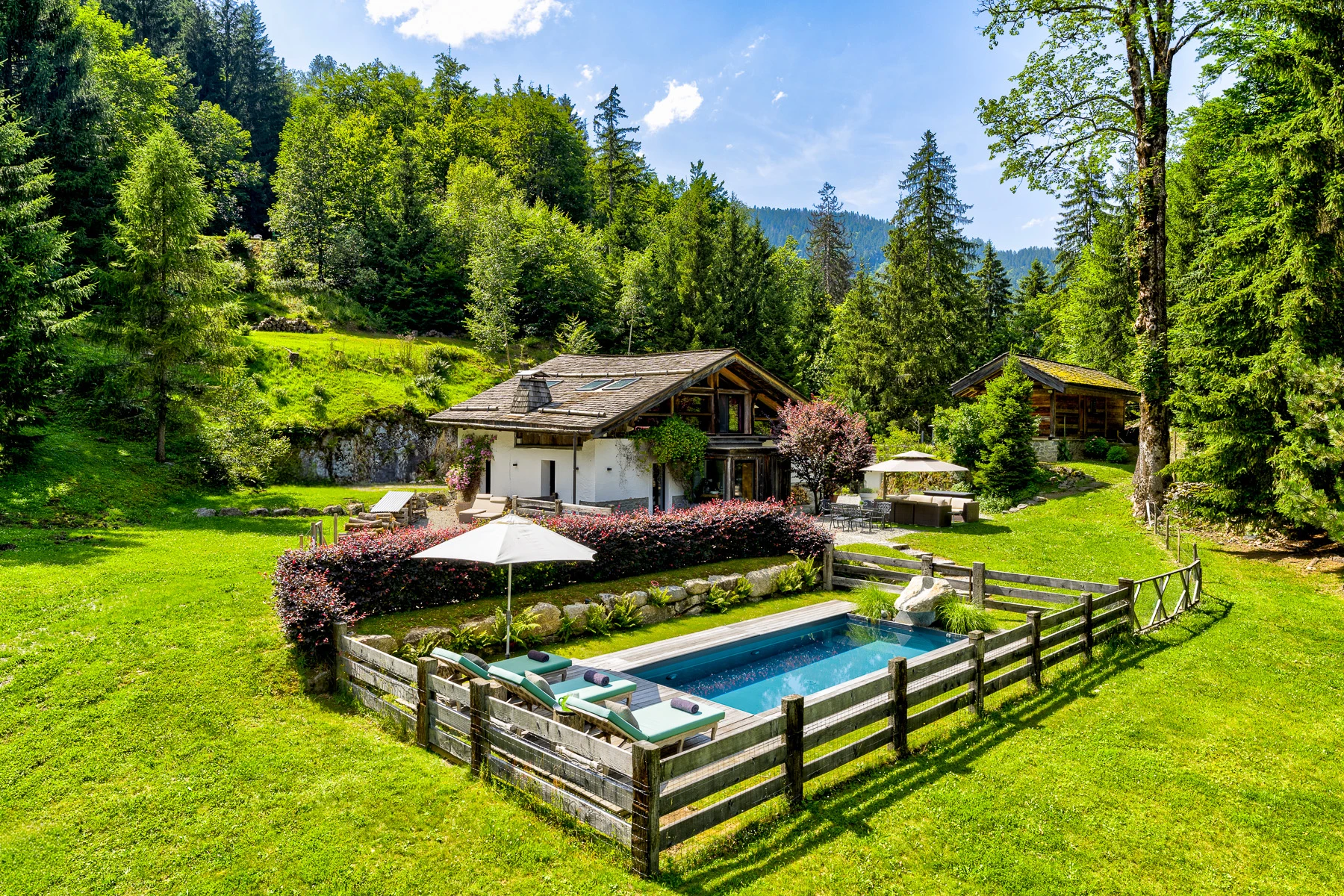 Vue de face du chalet La Forêt Dormante avec piscine et six hectares de propriété privée.