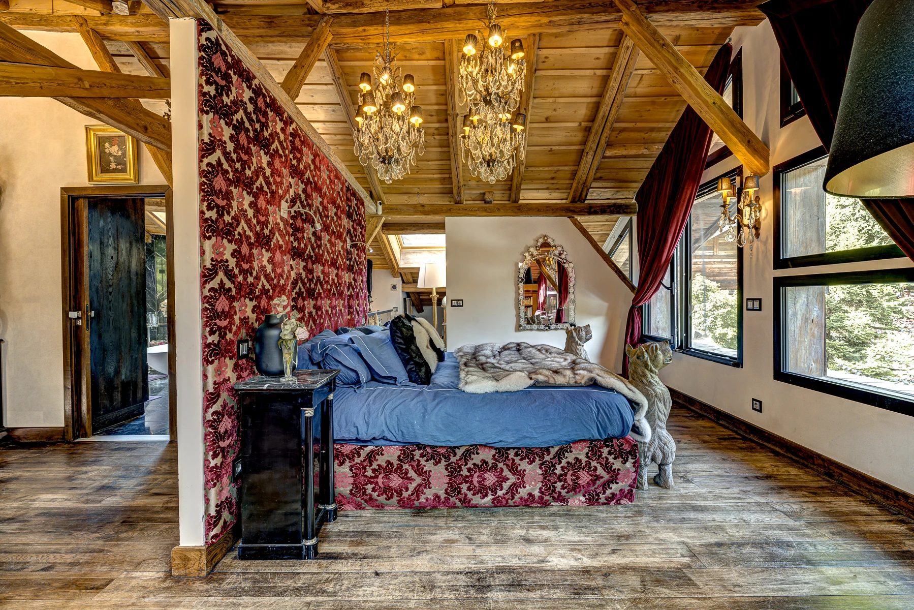 Photo de la chambre master. Lit king size, grandes fenêtres vue sur les montagnes, décoration de chalet de luxe.