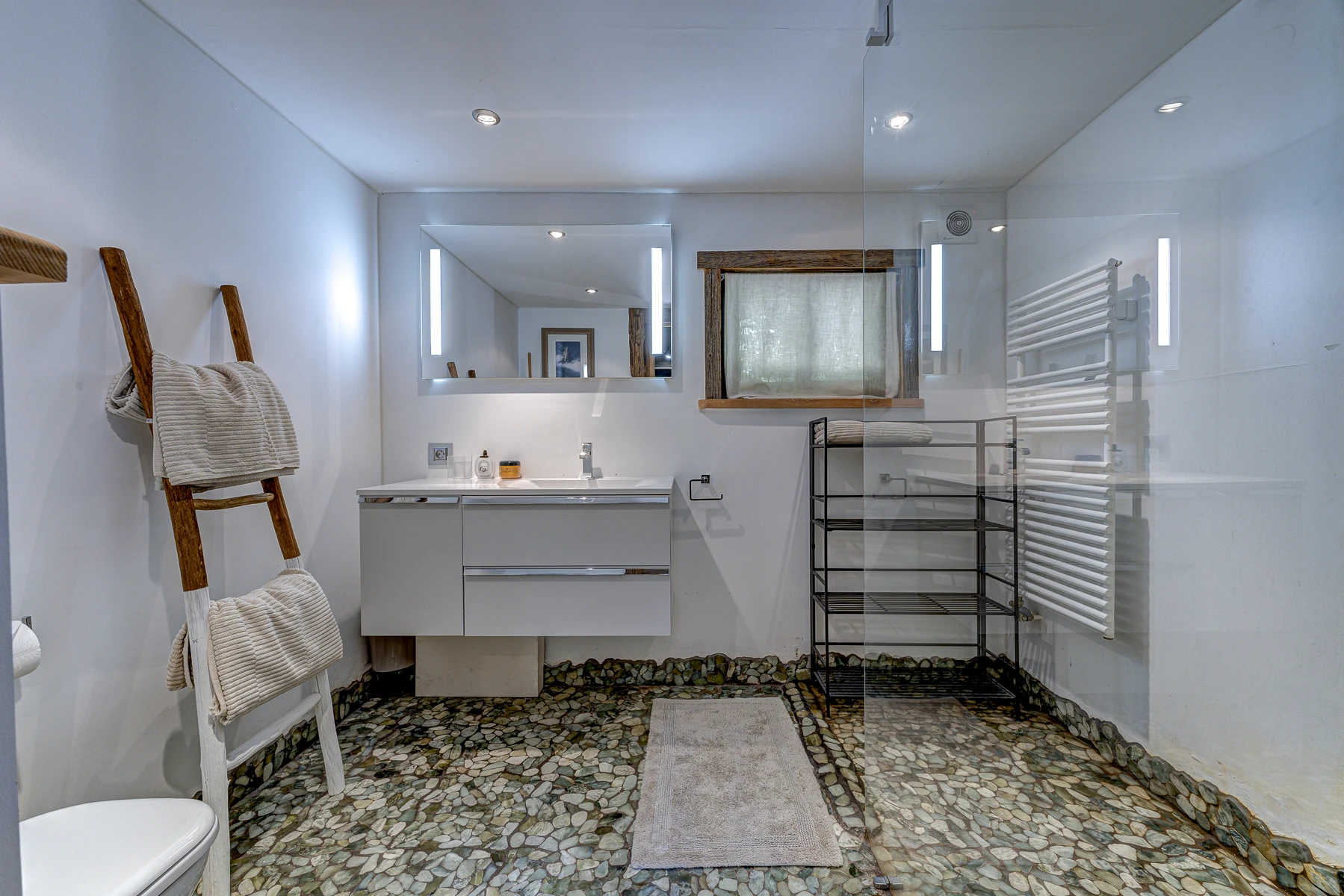 Photo de la salle de bain de la première dépendance. Une salle de bain pour 2 chambres, douche et toilettes, miroir, lavabo.